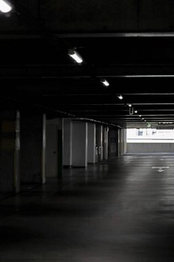 Ticari bir binanın çok katlı otoparkında gün içinde bile loş bir ışık.