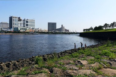 5 Mayıs 2018, Minato Ward, Tokyo, Japon baba ve iki oğlu Daiba Parkı 'ndaki kayalık dalgakıranda gezinerek Odaiba bölgesinin panoramik manzarasını sunuyorlar.