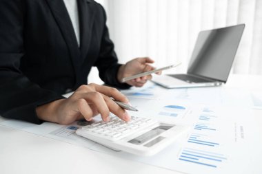İş adamı pazarlama veri grafiğini analiz ediyor ve ofiste, iş ve finans alanında hesap makinesi kullanıyor..