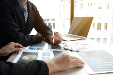 İki iş adamı ofiste iş grafiği ve planlama stratejisi, iş ve finans kavramını tartışıyor.