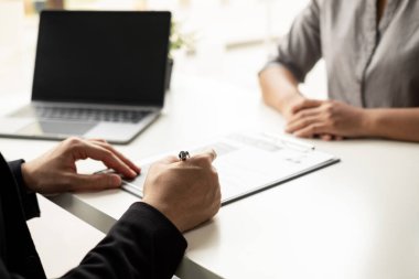 İşyeri sahibi, iş başvurusunda bulunanın iş başvurularındaki niteliklerini, iş başvurularını kontrol ediyor..