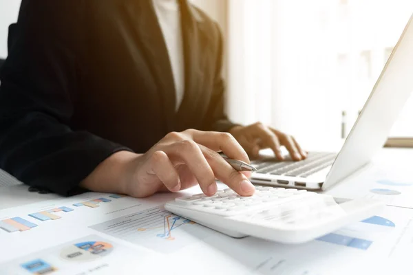 İş adamı pazarlama veri grafiğini analiz ediyor ve ofiste, iş ve finans alanında hesap makinesi kullanıyor..