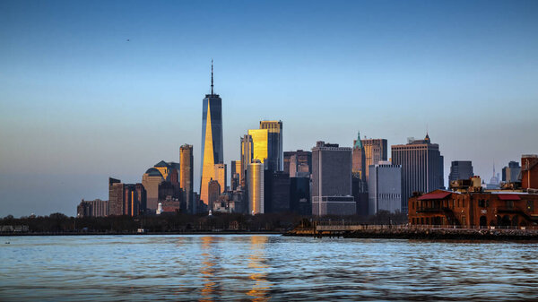 Manhattan from Hudson Bay Brooklyn, at sunset with light reflection in towers, New York