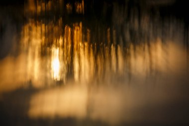 Doğal arkaplan için suda gün batımının bulanık yansıması