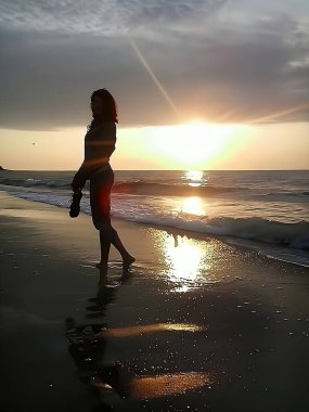 Bir kızın siluetinin fotoğrafı deniz kıyısındaki plajda gün doğumunun arka planına karşı..