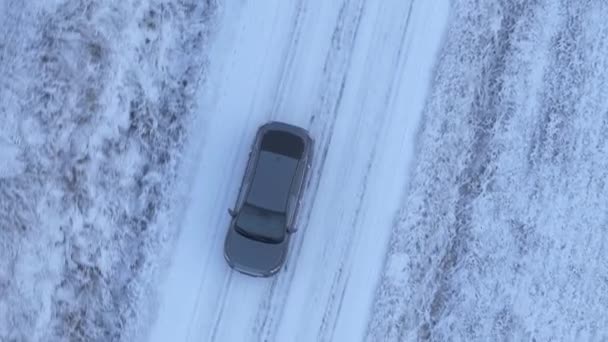 冬の国道を走る電気自動車の空中視界は氷の道で雪が降っています Dlog カラープロファイル — ストック動画