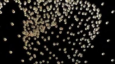 Altın küreler, eğimli bir zemin boyunca hareket eder ve akar. Bu soyut animasyon ışık yansımaları ile görsel olarak büyüleyici ve dinamiktir..