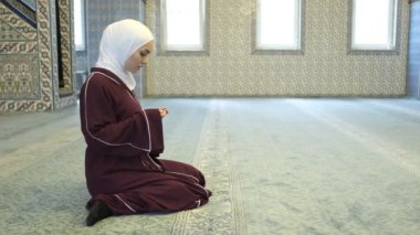 Camide namaz kılan Asyalı kadınlar, camide dua eden kızlar, ellerini kaldırıp Tanrı 'dan yardım isteyen İslami ibadetler.