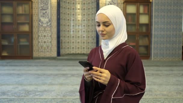 オンラインアプリでアジアの女性 モスクでヒジャーブの女の子の手に緑の画面を表示 イスラムアプリケーションの促進 — ストック動画