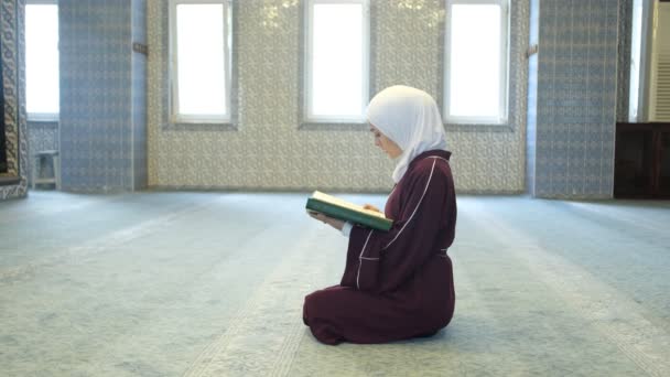 穆斯林女性崇拜 亚洲人劫持女孩阅读昆兰 年轻女孩坐在地板上阅读昆兰 穆斯林女孩在清真寺里 — 图库视频影像