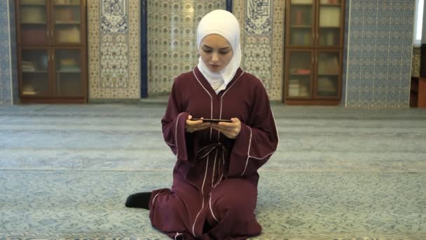亚洲女孩关于可兰经的申请 亚洲女孩在清真寺电话诵经后 伊斯兰式申请 — 图库视频影像