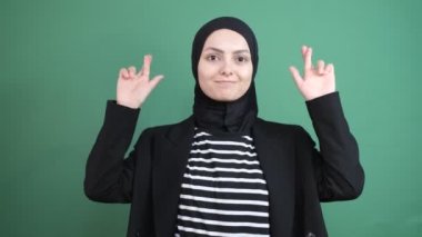 Baş örtüsü vaad ediyor, genç kız dini krom anahtarın önünde, insanlar gerçek konuşuyorlar, gülümseyen kadınlar, izole edilmiş yeşil arka plan