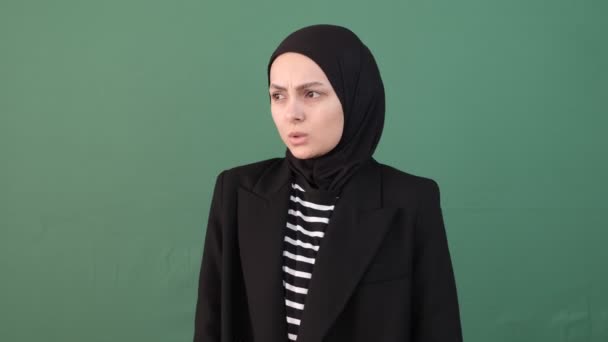 孤立した緑の背景の前でイスラム教徒の女性の寒さ 少女腕の上で クロマキーの隔離された背景を暖める — ストック動画
