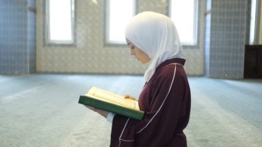 Kur 'an okuyan kız, yerde oturup Kuran okuyan genç kız, elinde Kuran kitabından dua eden Müslüman tesettürlü kadın.