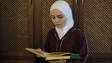 Asyalı kadınlar Kuran okuyor, tesettürlü kız Kuran okuyarak dua ediyor, İslam duaları ve istekleri, Arap alfabesindeki kutsal dini kitap