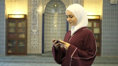 Müslüman Kadınlar Çevrimiçi İslam Kitabı, camideki tesettürlü kızın ellerinde yeşil ekranı gösteriyor, İslami uygulamaların tanıtımı