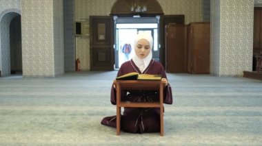 Asyalı Kız Camii, ibadet ve namaz, ahşap kürsüde Kur 'an okuyan tesettürlü kız, camide ibadet.