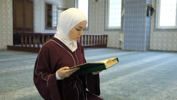 亚洲女孩阅读可兰经 年轻女孩翻阅可兰经 Hijab Muslim在清真寺朗诵可兰经 — 图库视频影像