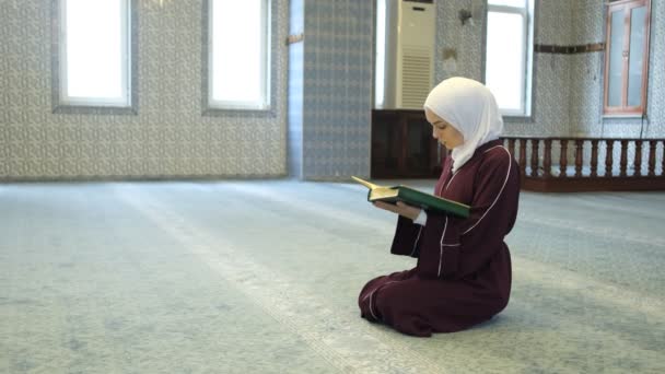 穆斯林女孩念经 手里拿着 古兰经 手里拿着 古兰经 在清真寺里祈祷 亚洲劫机女孩念经 — 图库视频影像