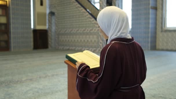 古兰经 在清真寺里为蒙面的穆斯林祈祷 戴头巾的女孩在讲台上诵读昆兰文 进行伊斯兰崇拜 — 图库视频影像