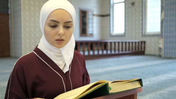 穆斯林女孩阅读古兰经 亚洲头巾女孩阅读清真寺内的古兰经 古兰经诵读 伊斯兰崇拜 — 图库视频影像