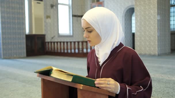 女孩祈祷古兰经 亚洲穆斯林女孩坐在她的膝上背诵昆兰 年轻女孩在清真寺举行的伊斯兰崇拜 — 图库视频影像