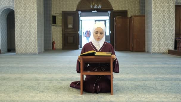 亚洲女孩在清真寺祈祷 伊斯兰崇拜和祈祷形式 劫持女孩在木制讲台上朗诵古兰经 在清真寺礼拜 — 图库视频影像