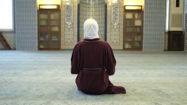 モスク内部の礼拝 モスク内部の膝に座っているヒジャーブの少女の礼拝 マスジド内部で祈っているイスラム教徒の女の子 — ストック動画