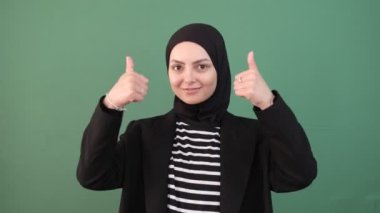 Müslüman kadın iyi, her şey yolunda, jestler gülümsüyor yeşil ekranın önünde genç insan, pozitif hissediyor