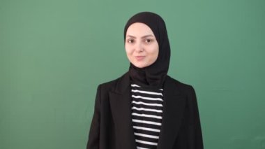 Yeşil Arkaplan Yapan Kız, Müslüman Kadın Tamam, Genç adam Yeşil Ekran 'ın önünde işaret parmağı imzalıyor, Kız jestler gülümsemesi