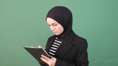 Başörtülü kız yazar, meşgul kadın, yeşil ekranın önünde düşünen kız, Müslüman kadın öğrenme, yeşil ekran krom anahtar