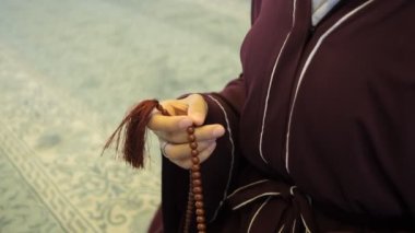 Müslüman Kadın Tespih Çekiyor, tespihi parmaklarıyla sayıyor, İslam ibadeti yapıyor, dhikr okuyor, tespihle dua ediyor.