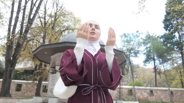 モスクの中庭で手を空に上げて祈る少女のイメージ イスラム教の祈りのテーマ — ストック動画