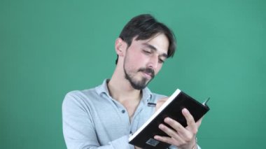 Genç adam defterde öğrendiklerini yazıyor, ciddi bir iş adamı notlar alıyor, bir üniversite öğrencisi not defteri ve kalem kroma anahtarıyla öğrenme dersleri alıyor.