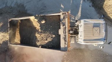 Çöp kamyonu inşaat alanındaki kumu boşaltıyor, hava görüntüleme kamyonu kum döküyor, kum işlem için boşaltılıyor, insansız hava aracı görüntüsü