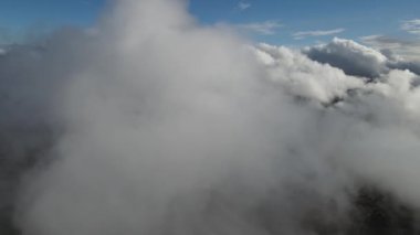 Gün batımında kümülüs bulutlarının, dağların, köyün ve renkli gökyüzünün havadan görünüşü, yüksek kayaların, ormanın ve gökyüzünün olduğu güzel bir manzara.