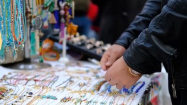 Genç turist sokakta durup hediyelik bilezik ve boncukları seyrediyor. Turist temalı bir imaj çiziyor, hediyelik eşya alıyor ve ülkeden hediyeler alıyor.