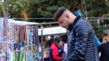 Ardışık boncuklar, turist temalı imgelerle oluşturulan hediyelik eşya dükkanındaki tespihlerin resmi. Ziyaret ettikleri ülkeden el yapımı hediyelikler.