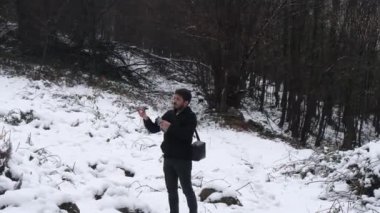  İHA 'nın karlı ormanı gezerken, işini bitirirken ve onu kapatırken görüntüsü.