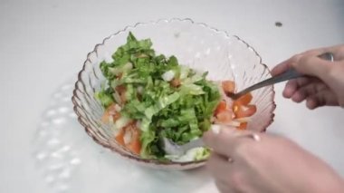 Akşam yemeği için yapılmış salata resmi, domates ve yeşilliklerden yapılmış yeşil salata, beyaz arka planda karıştırılmış salata.