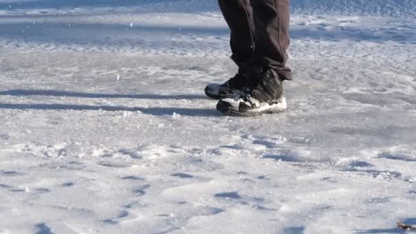 凍った湖の中で斧で水に到達し自分のための水の穴を作るために氷の上の層を壊す若い男の概念的なイメージを破る — ストック動画