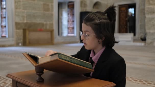 Kleiner Junge Anzug Liest Quran Auf Einem Holzständer Der Moschee — Stockvideo