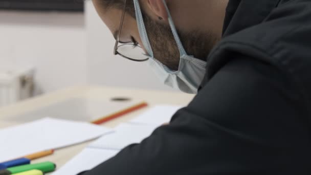 男性のマスク研究 パンデミックでの試験 マスクでの質問の解決 クラスでノートを取る男性学生 — ストック動画