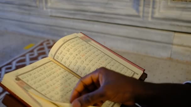 アフリカの男がクルアーンを読むと 10代の若者は宗教書のページ モスクで崇拝する若者を通して噂されています — ストック動画