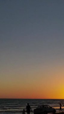 Günbatımını hızlandırmak, insanların gün batımında sahilde hızlı bir şekilde hareket etmeleri, gün batımında telaşlı ve telaşlı insanlar.