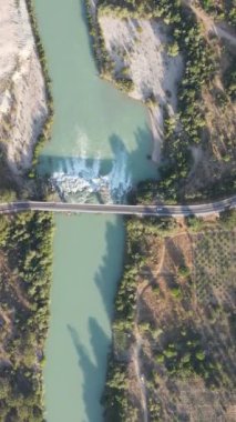 Köprü bir nehrin üzerine inşa edilmiş, vadiden akan, dolambaçlı bir yol ve hava manzarası.