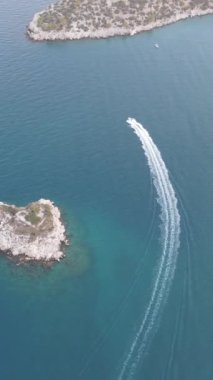 Sürat teknesinin hava manzarası, sürat teknesi harika koylarda geziniyor ve inanılmaz bir hava manzarası yaratıyor, küçük bir ada ve mavi sular.