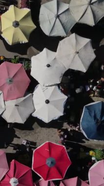 Drone footage of shopping markets set up on the street, street shopping covered with umbrellas and tents, shopping tents set up on the road between the apartments