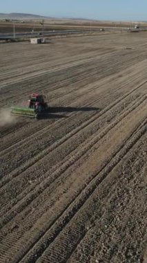 Aerial drone view of tractor tilling the land, working with tractor in farmland, image of tractor farming in wide soil