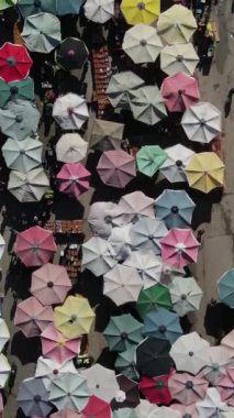 Drone footage of shopping markets set up on the street, street shopping covered with umbrellas and tents, shopping tents set up on the road between the apartments